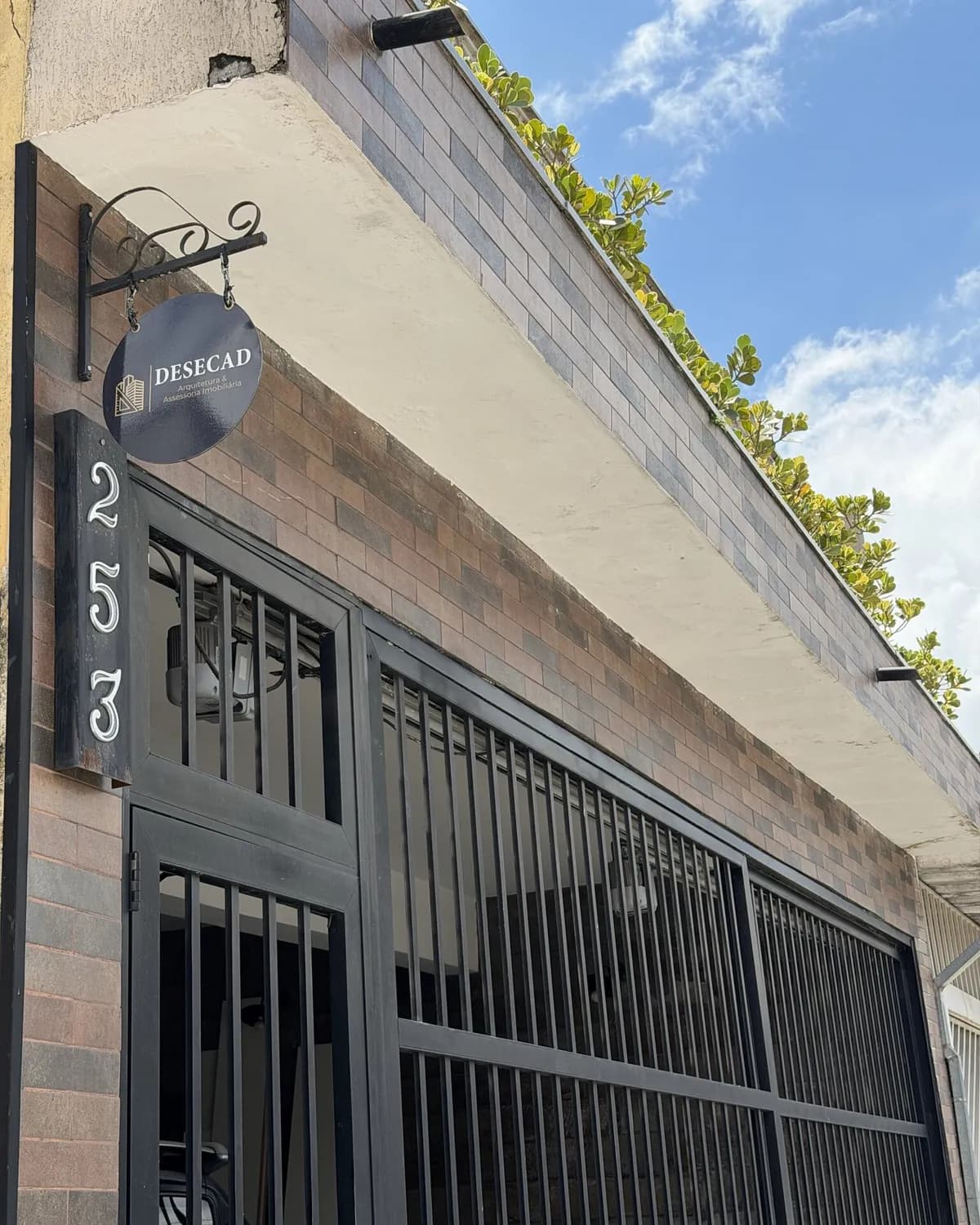 Fachada do escritório da Desecad Arquitetura e Assessoria Imobiliária com a placa do logo e o número 253, na Rua Brigadeiro Henrique Fontenelle, Parque São Domingos, São Paulo